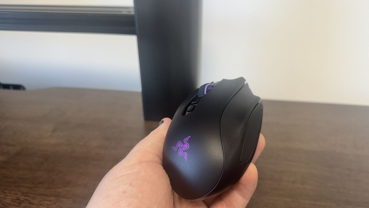 Die Razer Naga V3 Pro wird in der Hand gehalten, das beleuchtete Razer-Logo ist sichtbar