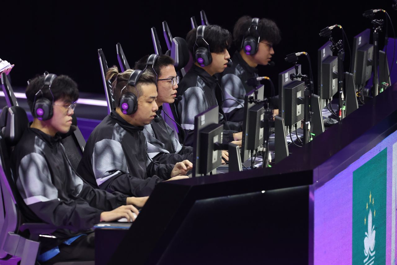 Esports-Team an einer Reihe von PC-Stationen während eines Wettkampfs auf der Bühne