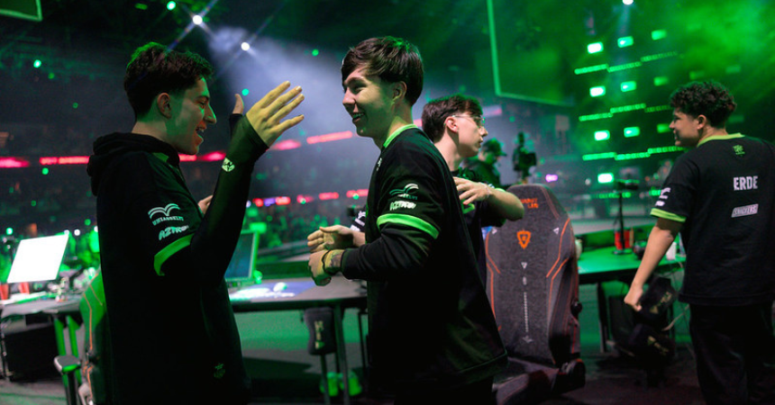 Spieler von LOUD klatschen sich auf der Bühne in São Paulo nach ihrem Sieg gegen NRG in grünem Bühnenlicht ab