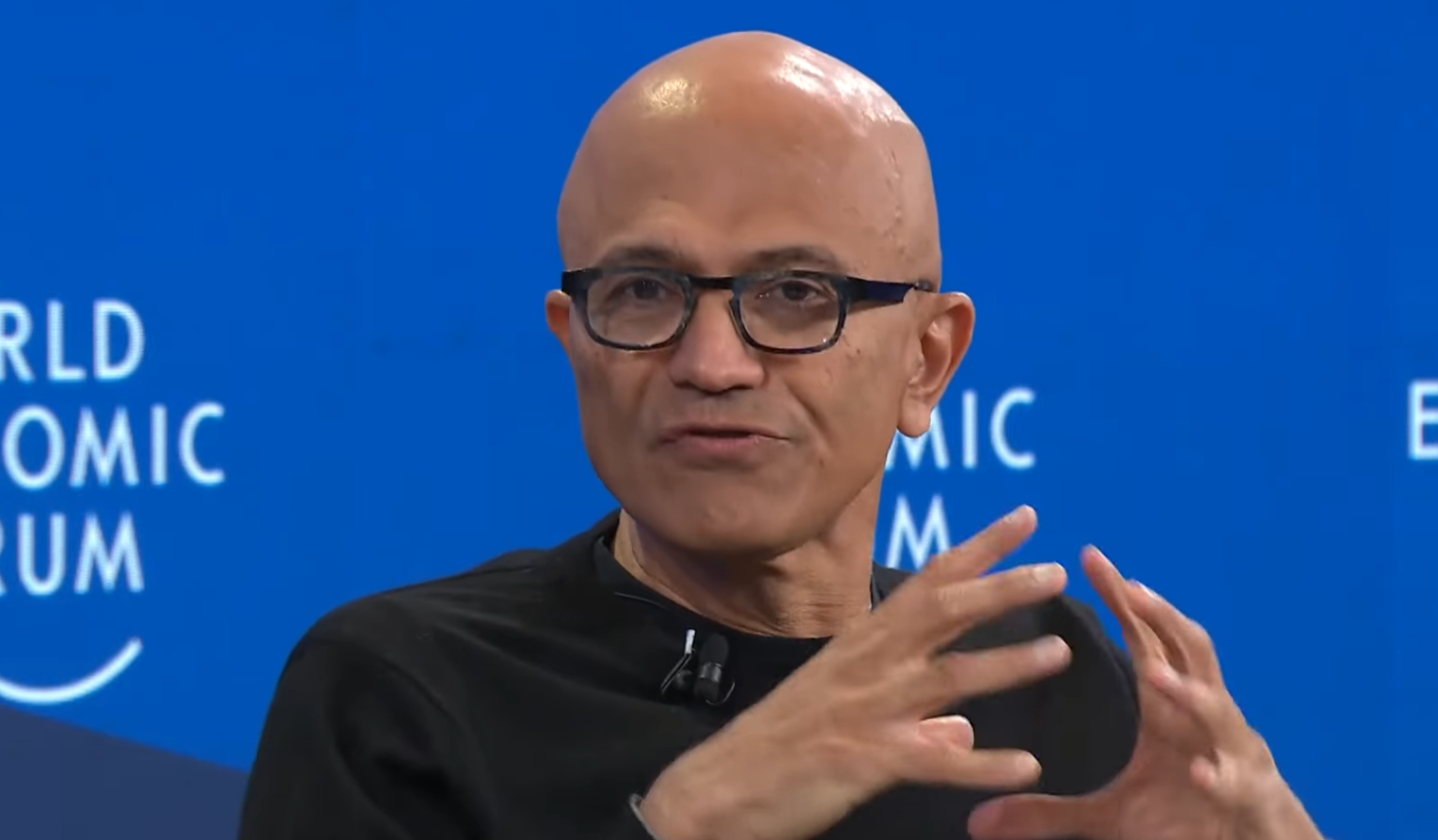 Microsoft-CEO Satya Nadella spricht auf einer Bühne und gestikuliert mit beiden Händen