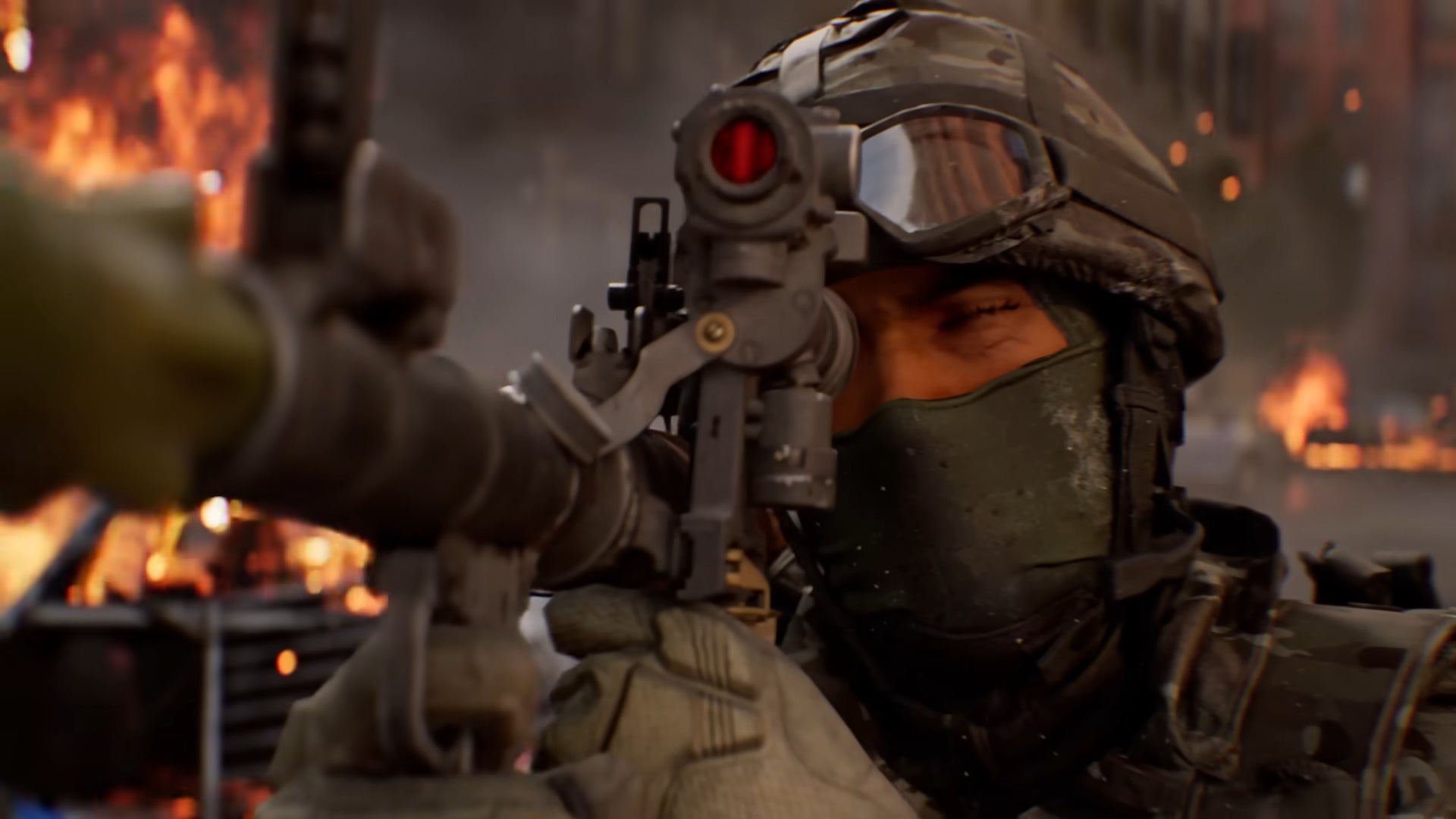 Nahaufnahme eines Soldaten mit Maske und Helm, der in Battlefield 6 über Visier und Rohr zielt, dahinter brennt die Stadt
