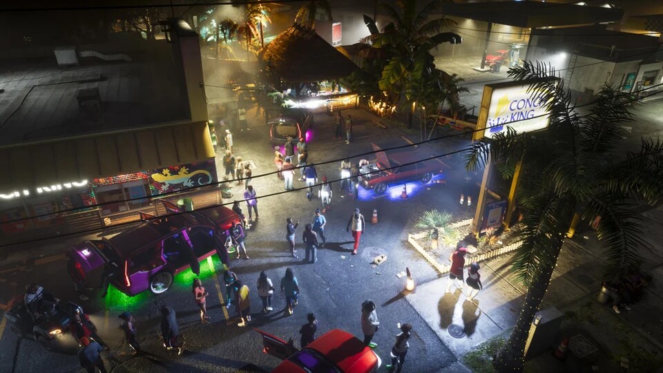 GTA 6: Feiernde Menschenmenge nachts vor dem Gebäude Conch King mit Autos mit Neon-Unterbodenbeleuchtung